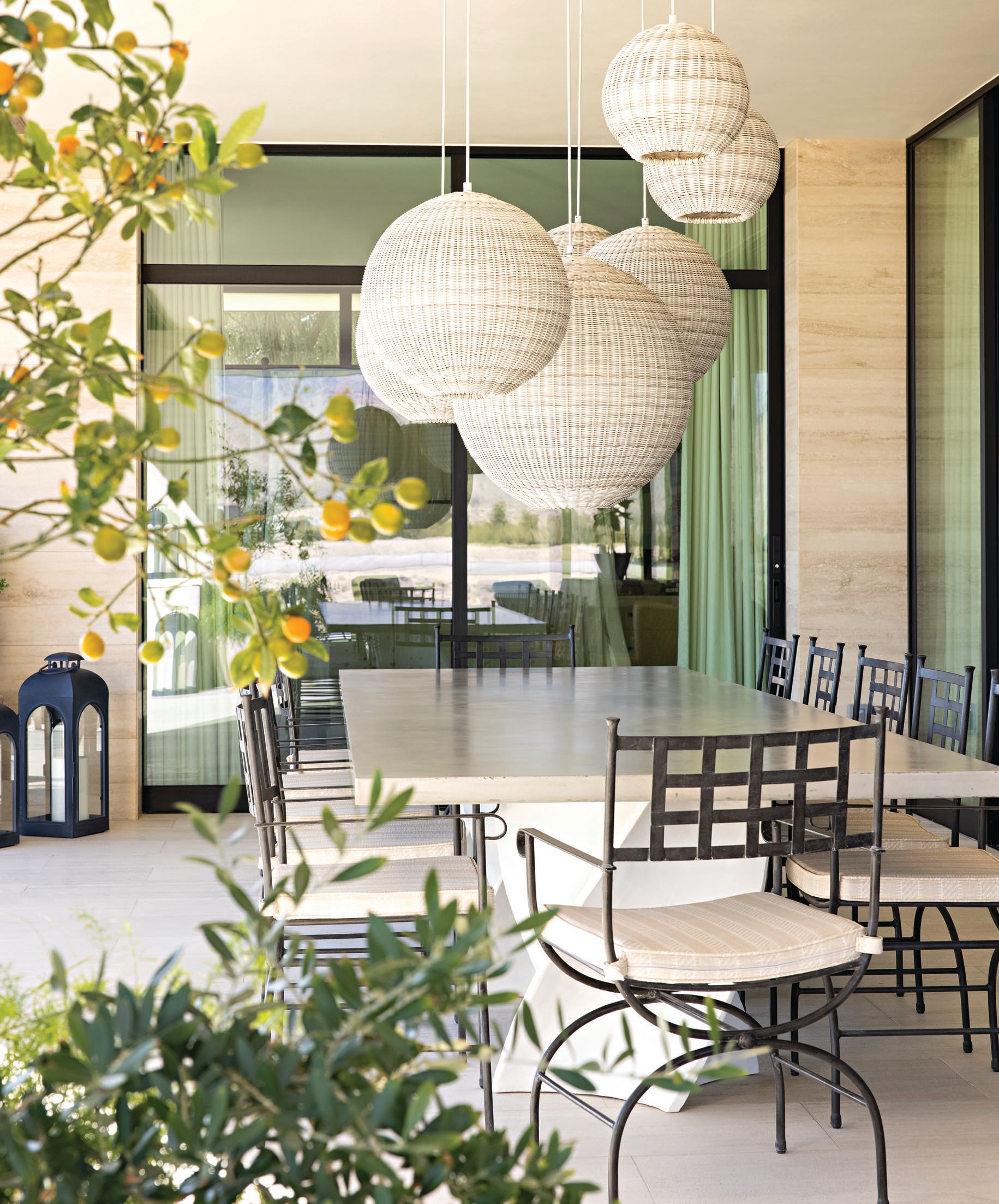 Pendant lights illuminate the outdoor dining area, where the sprawling table offers room for up to 10 guests. PHOTOGRAPHED BY KARYN MILLET PHOTOGRAPHY