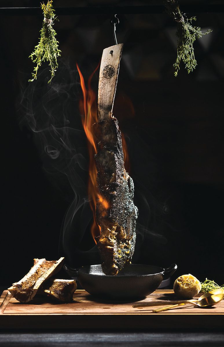 The fiery bone marrow and tomahawk dish goes big on presentation. INTERIOR PHOTO BY AVABLU