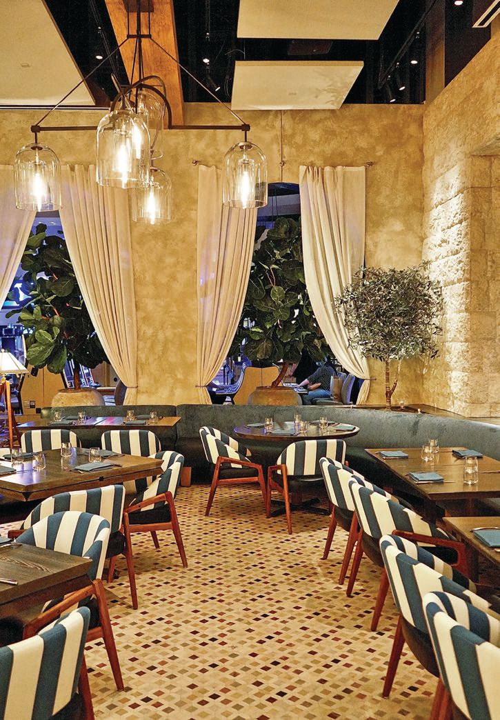 “I love the golden glow from our 30-seat bar and lounge,” says Flay. “You’ll notice the Amalfi Coast-inspired blue-and-white-striped chairs in the lounge, which are a nod to the swarms of striped umbrellas and chairs sprawled across the beaches there”. PHOTO COURTESY OF CAESARS PALACE LAS VEGAS